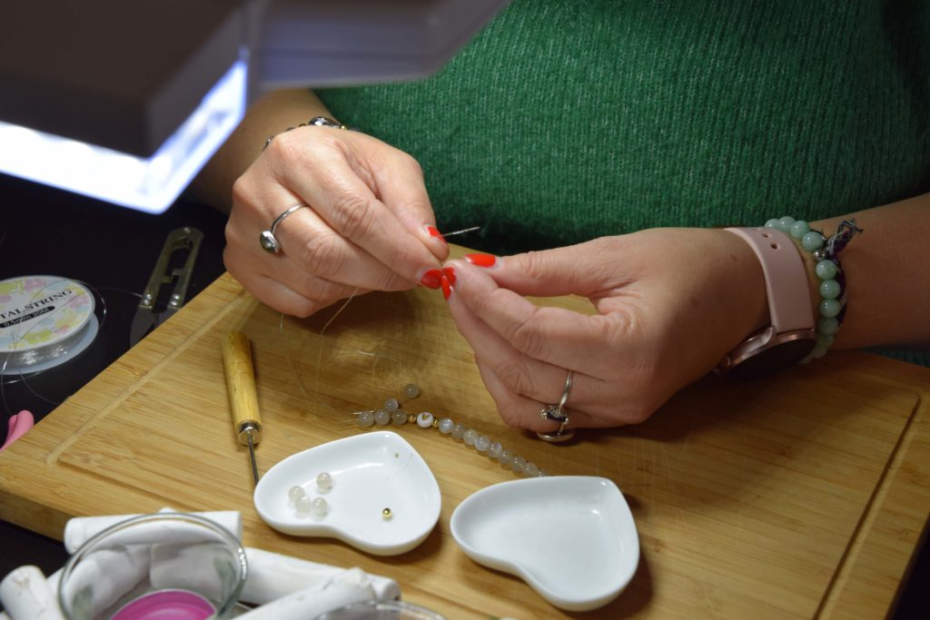 Perles-et-colibris-creatrice-de-bijoux-Mitry-Mory-Marie-Paule-enfile-les-perles-pour-creer-un-bracelet